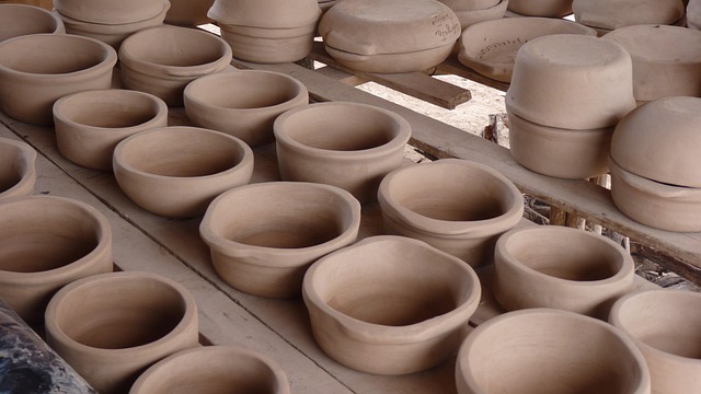 artisan hands shaping clay pottery in warm studio light