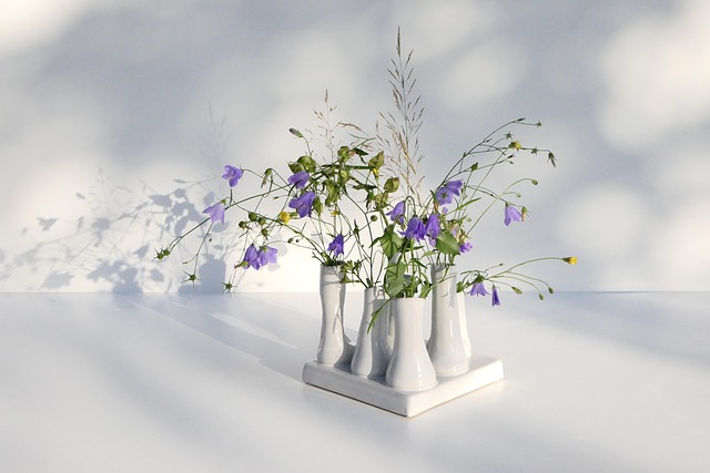 handcrafted ceramic bowl and vase styled on warm white linen tablecloth natural light